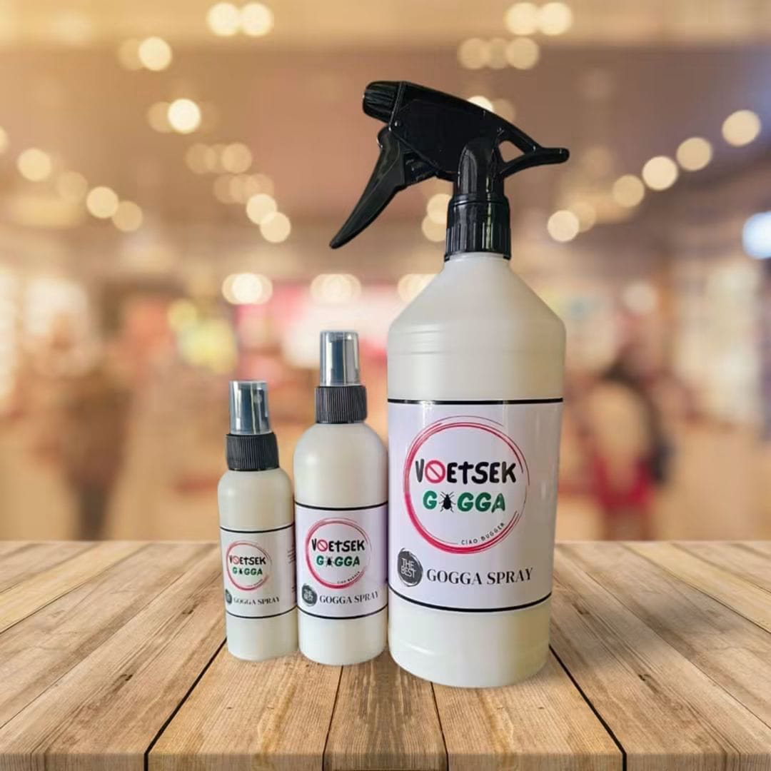 Three bottles of Voetsek Gogga Spray in 100ml, 250ml and 750ml trigger-spray sizes on a wooden surface.