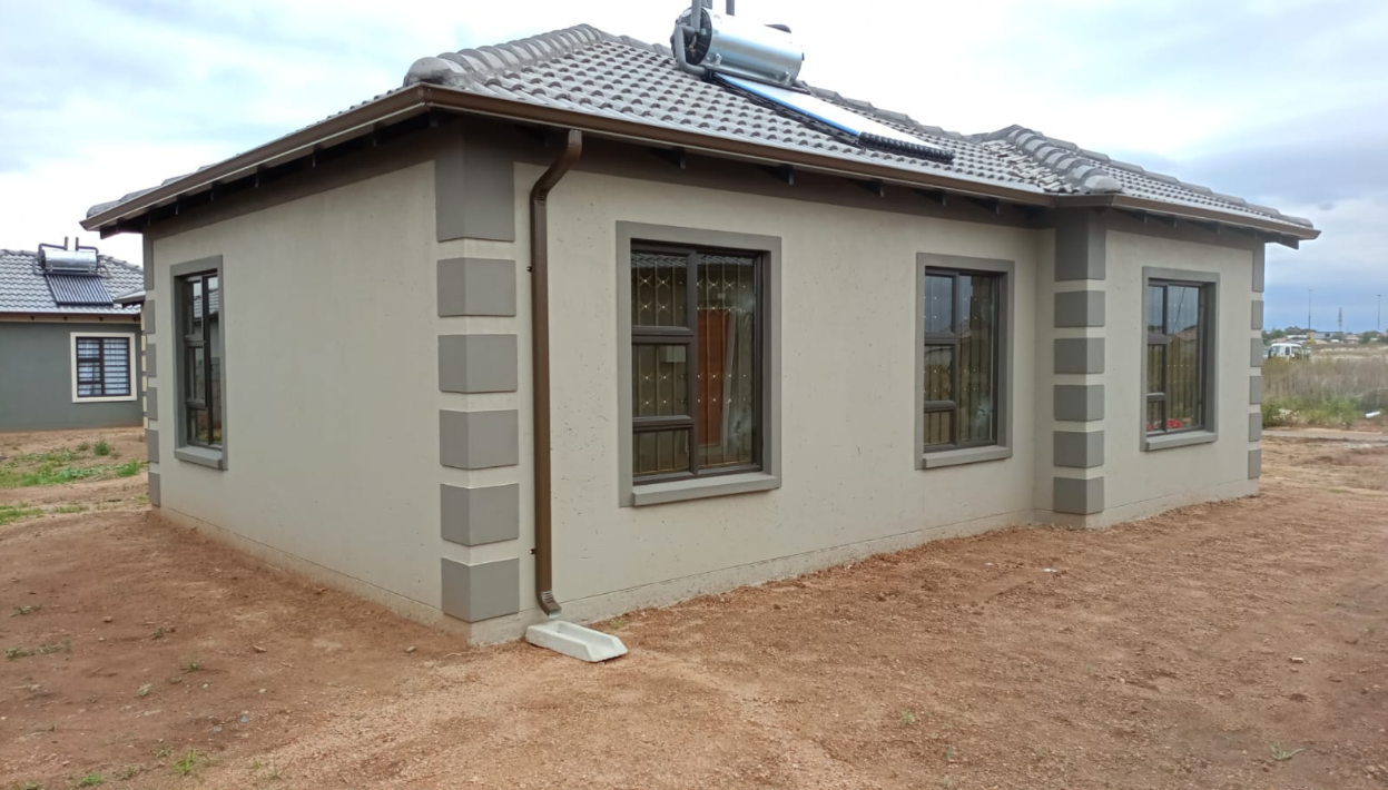 Three-bedroom single-bathroom Tuscan-roof home at WindmillPark with full-height security windows and grey plaster facade.