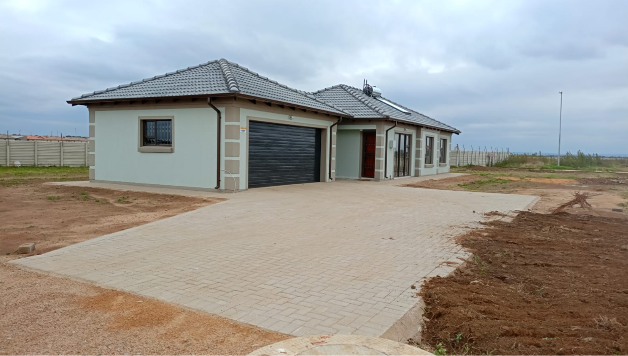 Four-bedroom Tuscan-roof family home at WindmillPark with double automated garage, paved driveway and matching corner detailing.